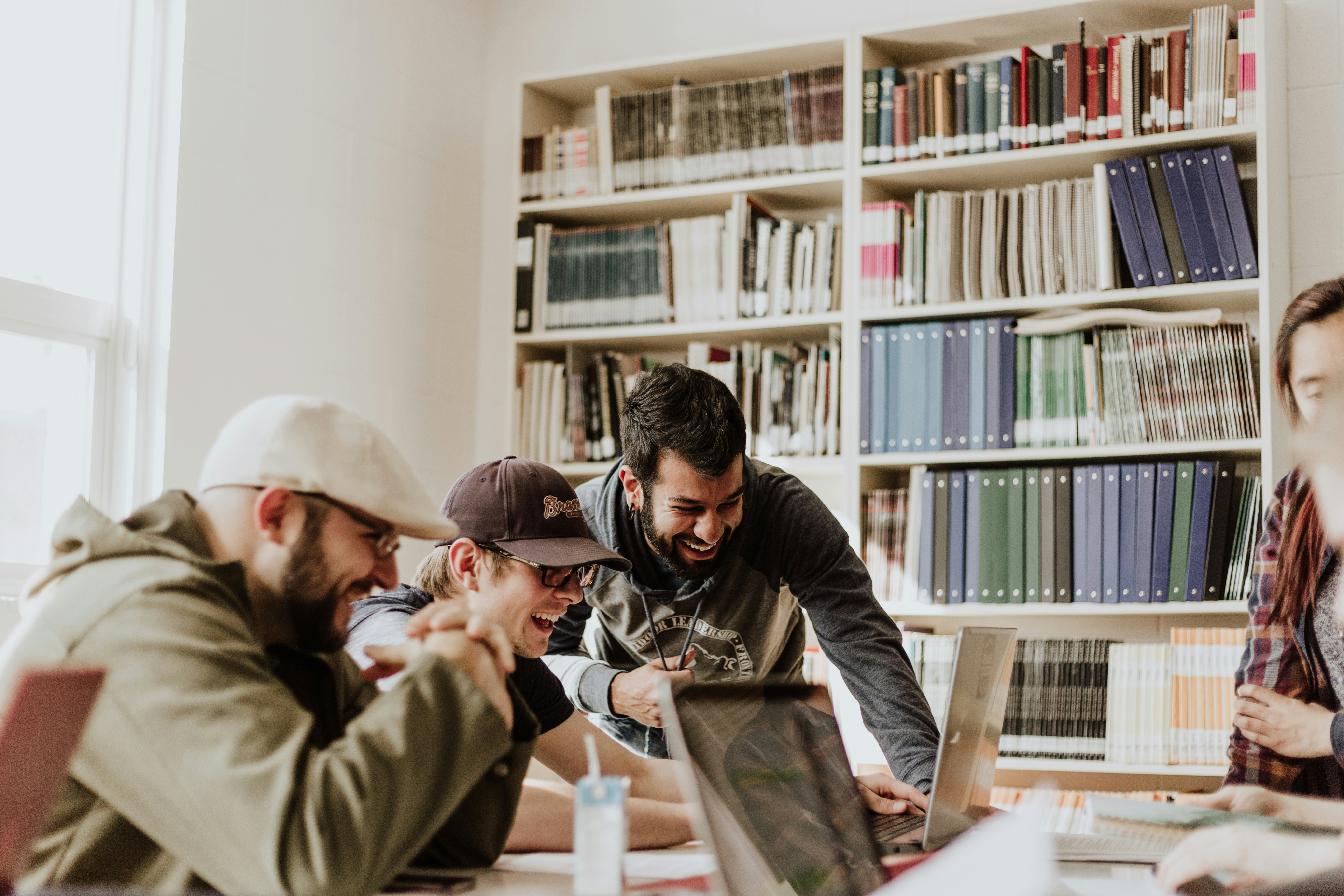 A startup team collaborating around laptops in a bright workspace